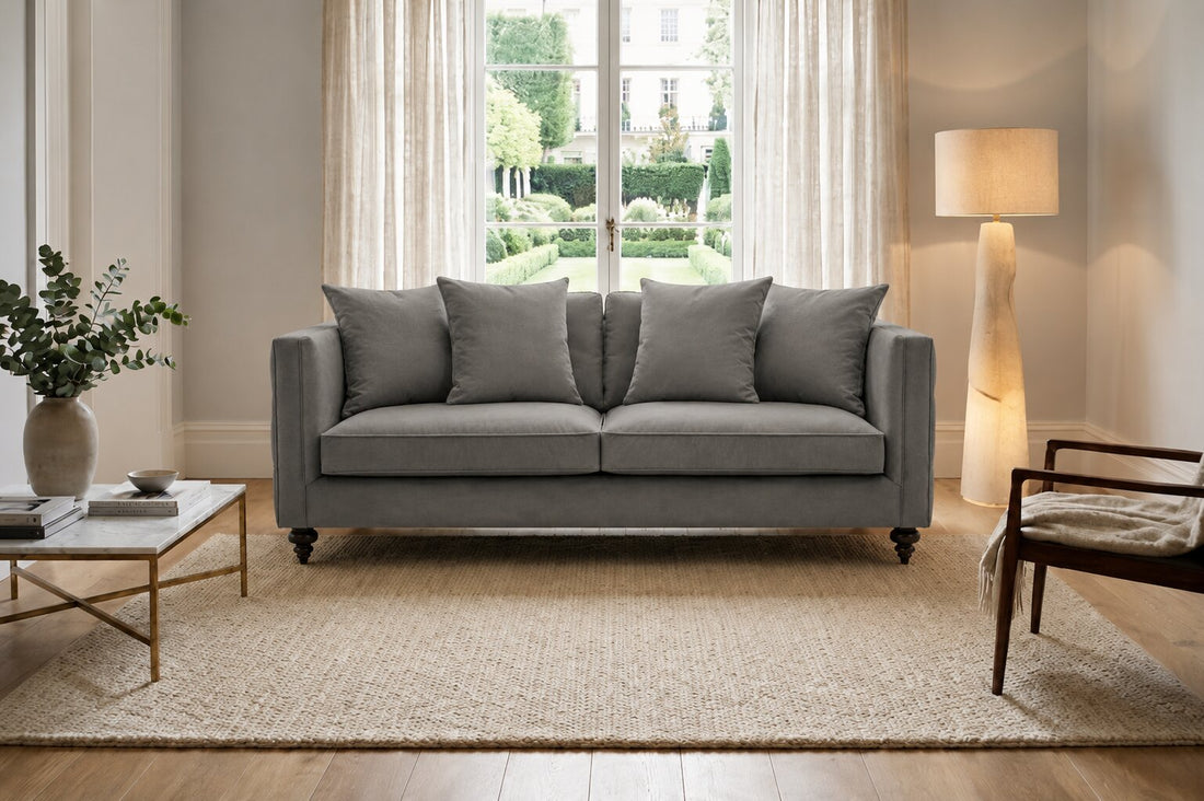 A gray upholstered loveseat with four matching back cushions, shown from the front on a plain white background.
