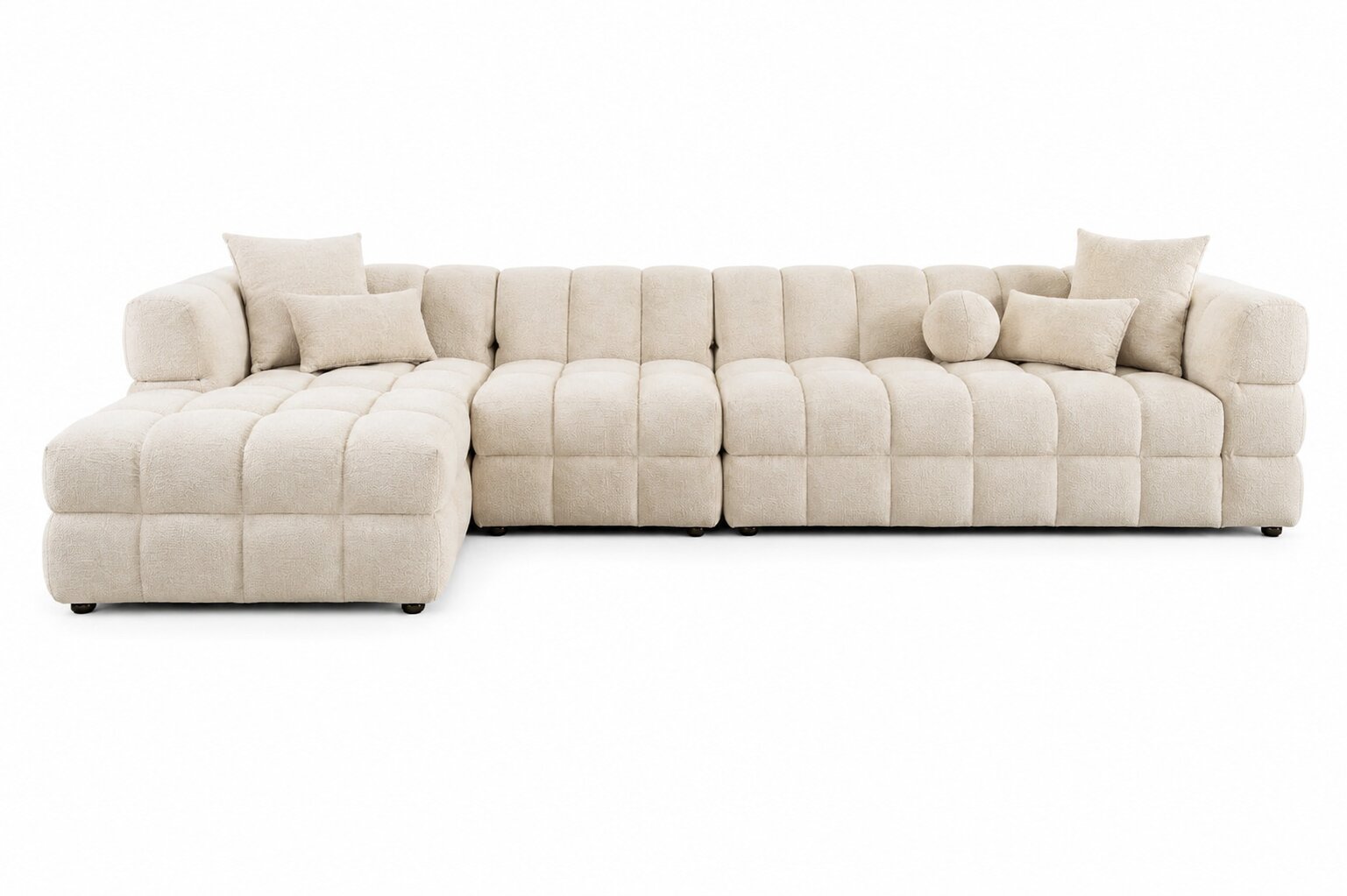 A modern sectional sofa in a light beige tufted fabric, featuring a left-facing chaise lounge and multiple matching throw pillows, shown against a plain white background.