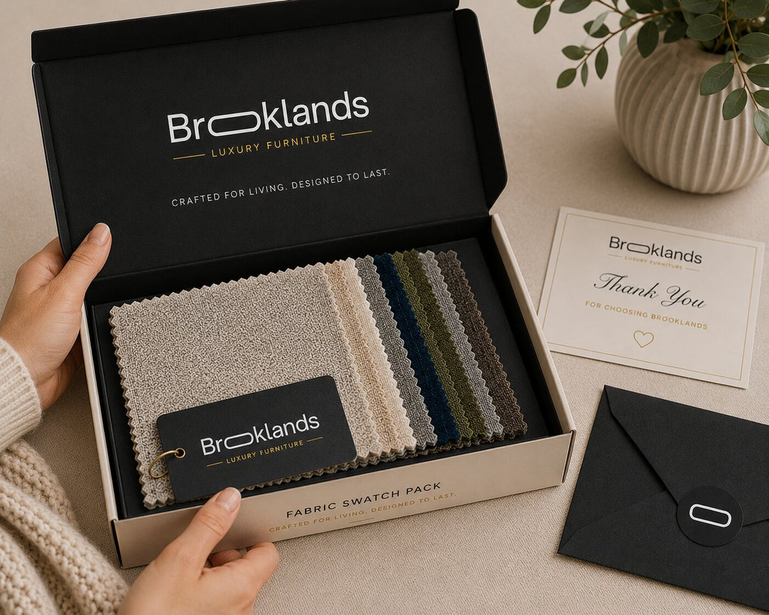 Broklands Fabric Swatch Pack displayed on a neutral surface, featuring a black and cream retail box, a thank-you card, a black envelope, and multiple fabric swatch samples in neutral and dark tones.