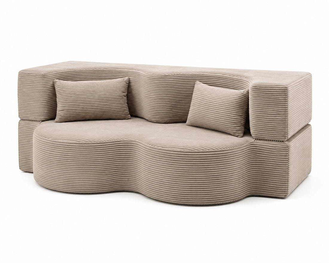 A modern wavy sectional sofa upholstered in a textured taupe corduroy fabric, featuring two matching square throw pillows, shown against a plain white background.